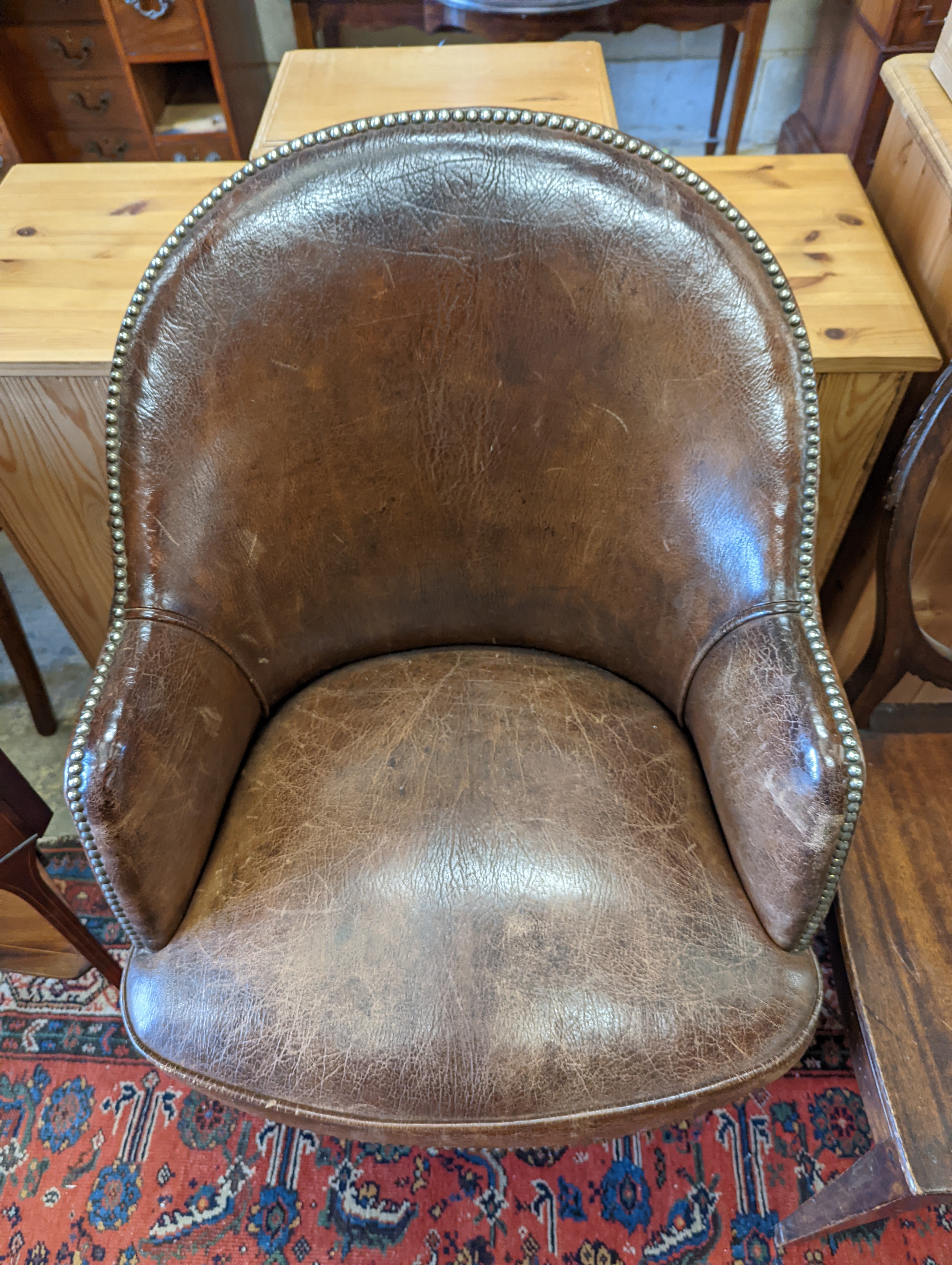 A brown leather upholstered desk chair, a mahogany hall chair and two upholstered armchairs